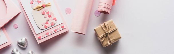 top view of valentines decoration, gifts, hearts and wrapping paper on white background, panoramic shot - 写真・画像