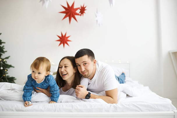 happy family mother father and child on Christmas morning in bed - Foto, imagen