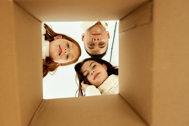 Family unpacking cardboard boxes at new home on a white backgrou - Foto, afbeelding
