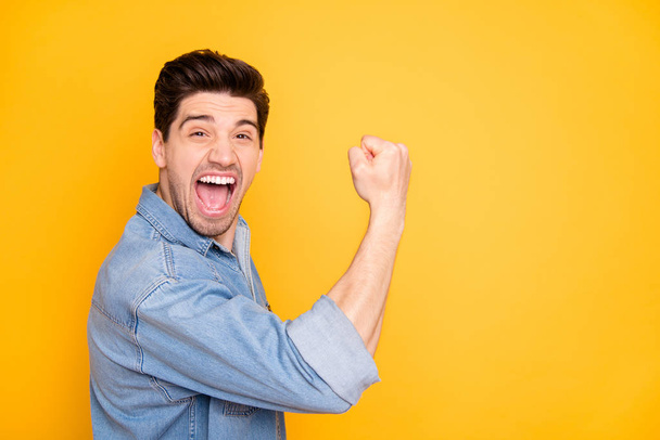 Side profile photo of cheerful positive crazy guy expressing rude scream on face showing muscles in jeans denim isolated vibrant color background - Foto, immagini