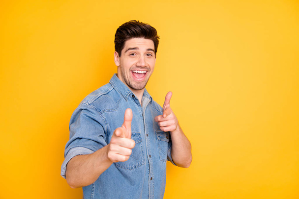 Photo of cheerful positive handsome man with good mood pointing at you to praise you smiling toothily isolated yellow vivid color background - Foto, Bild
