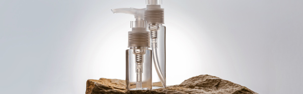 dispenser cosmetic bottles on stone on white background with back light, panoramic shot - Photo, Image