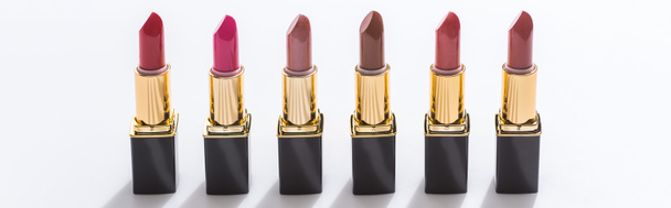 assorted lipsticks in luxury tubes in line on white background, panoramic shot - Photo, Image