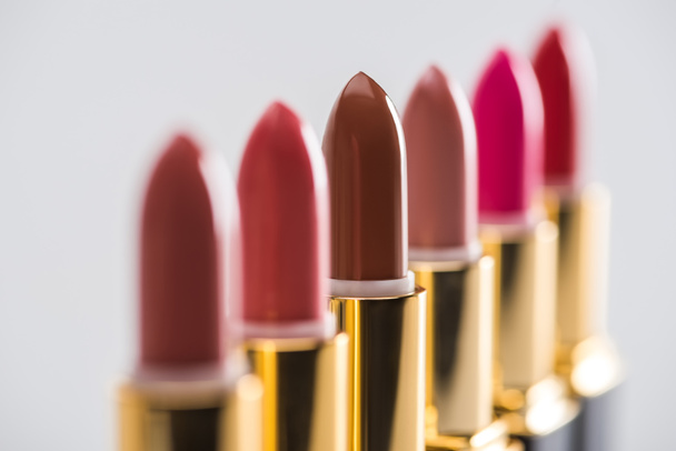 close up view of assorted lipsticks in luxury tubes in line isolated on white background - Foto, afbeelding
