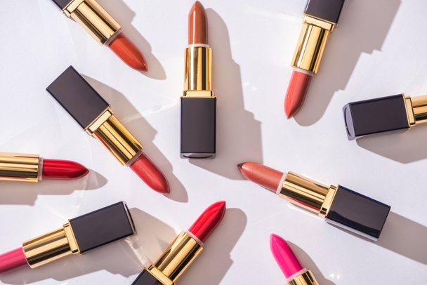 top view of assorted lipsticks in luxury tubes on white background - Photo, Image