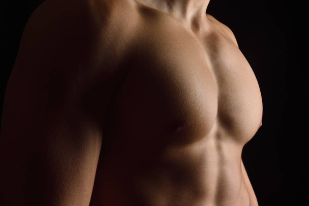 naked breast of a man on black background - Фото, зображення