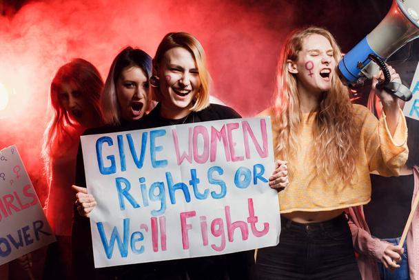 Porträt einer emotionalen Feministengruppe im verrauchten Raum - Foto, Bild