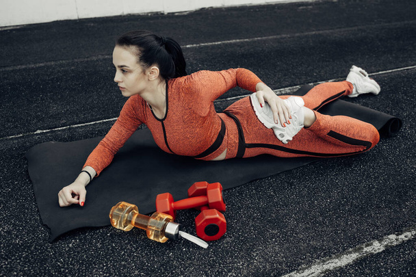 Portré egy sport Fitness lány öltözött divat sportruházat ruha csinál Stretches Gyakorlat és képzés a városi stadionban, egészséges életmód koncepció - Fotó, kép