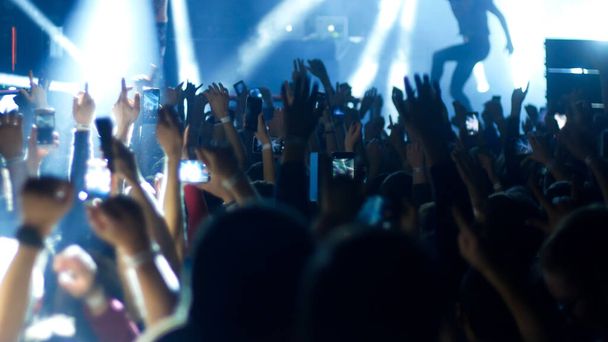 Folle energica che balla con le mani alzate al concerto rock - illuminazione blu
 - Foto, immagini