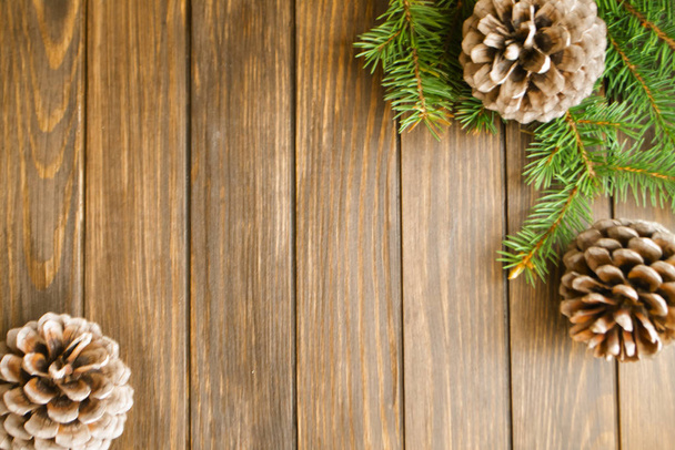 木の板の上に太い枝と松のコーン。コピースペースとクリスマスの背景. - 写真・画像