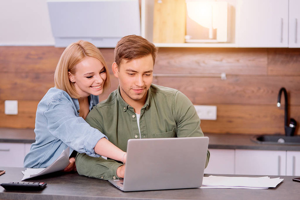 lovely positive couple checking their finance at home - Photo, image