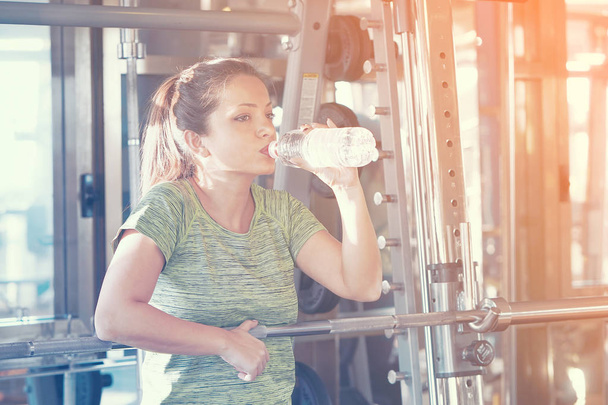Fitness athlete woman drinking water after training work out exercising. - Photo, image
