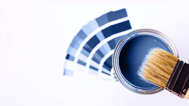 Paint brushes placed on top of can filled with blue paint. Classic blue color of year 2020. - Photo, Image