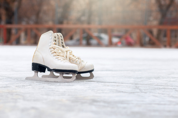 A pair of White Figure Skates are standing on an open ice rink. Winter sport - Фото, зображення