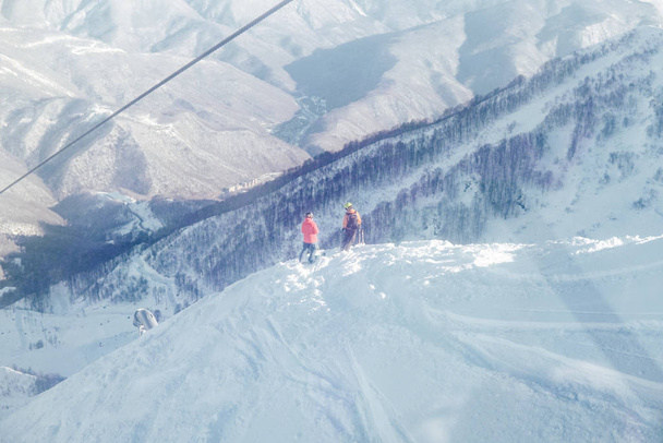 esquiadores y snowboarders viajan en las pistas de montaña de la estación de esquí
 - Foto, Imagen