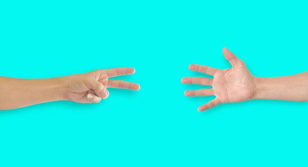 zwei Hände spielen Steinpapier-Schere auf blauem Hintergrund - Foto, Bild