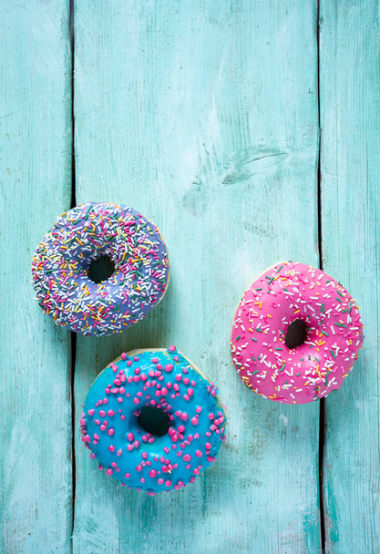 colorful doughnuts on turquoise surface - Foto, Imagen