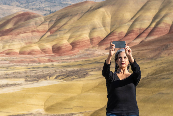 Una joven morena con hebras grises se hace selfies en Painted Hills Overlook
 - Foto, Imagen