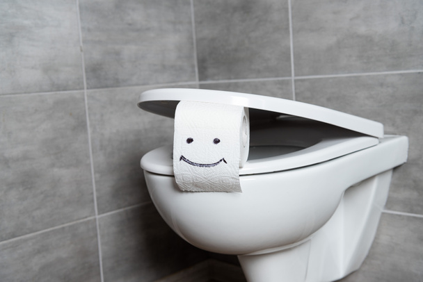 Туалетная бумага с табличкой улыбки на унитазе в туалете
 - Фото, изображение