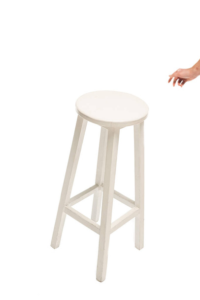 Oříznutý pohled muže táhnoucí ruku na bílou stoličku izolovanou na bílém  - Fotografie, Obrázek