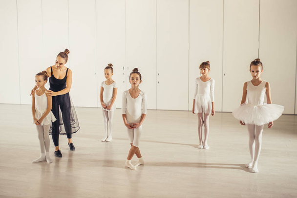 young professional ballerina practicing and teaching children - Foto, imagen