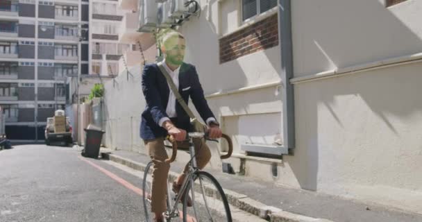 Front view of a young Caucasian businessman on the go in the city, riding a bike in the street, slow motion - Filmati, video