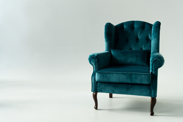 Comfortable turquoise armchair on grey background - Photo, Image