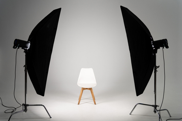 Λευκή μοντέρνα καρέκλα με φως στούντιο σε γκρι φόντο - Φωτογραφία, εικόνα