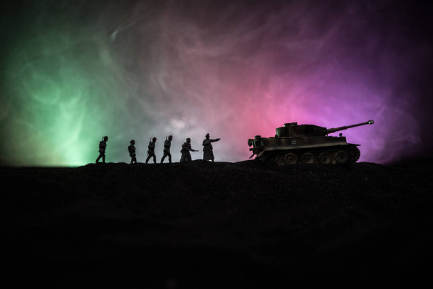 War concept. Militaire silhouetten vechten scène op oorlog mist hemel achtergrond, Wereldoorlog Duitse tanks silhouetten onder bewolkte skyline 's nachts. Aanvals scène. Gepantserde voertuigen en infanterie. - Foto, afbeelding