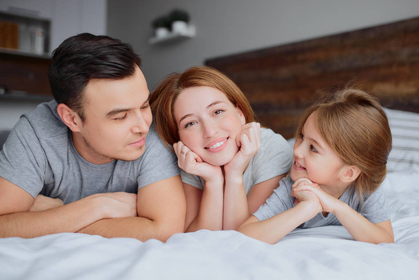 portrait of young family on bed - Foto, Imagen