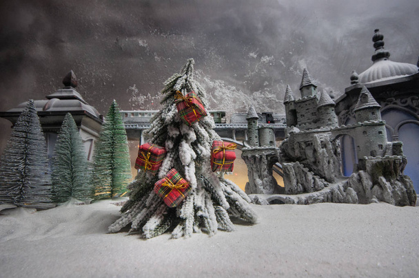 Миниатюра зимней сцены с рождественскими домами, вокзалом, деревьями, покрытыми снегом. Вечерняя сцена. Новый год или рождественская концепция. Селективный фокус
 - Фото, изображение