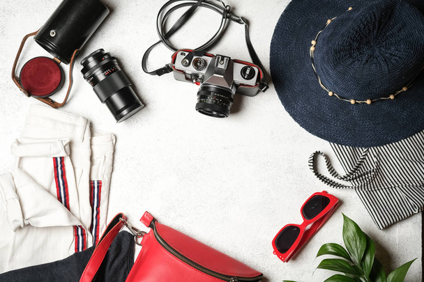 Set dameskleding en accessoires voor zomervakantie reizen in rode, blauwe en witte kleuren. Reisvakantie concept. Zomer achtergrond. Bovenaanzicht kopieerruimte. - Foto, afbeelding