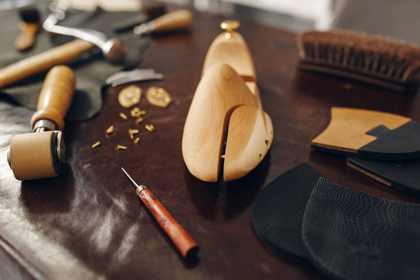 Shoemaker työkalut, jalkineiden korjaus palvelu, kukaan. Kengänvalmistustyöpaja, saappaanvalmistuslaitteet pöydällä, suutarin työ
 - Valokuva, kuva