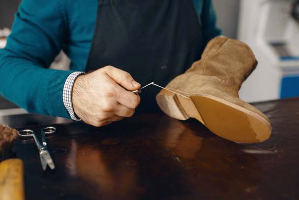 Shoemaker šije boty, oprava obuvi. Řemeslnické dovednosti, obuvnická dílna, ševcovská práce - Fotografie, Obrázek