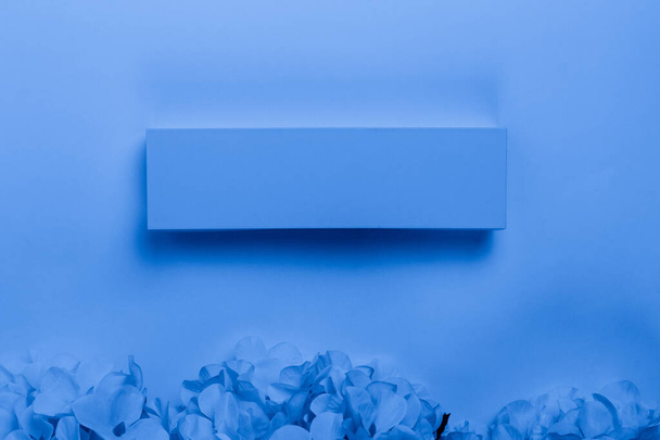Regalo o regalo caja y flor en un backgrou azul clásico de moda
 - Foto, Imagen