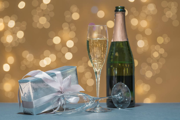 Copos e garrafa de champanhe com uma caixa de presente
 - Foto, Imagem