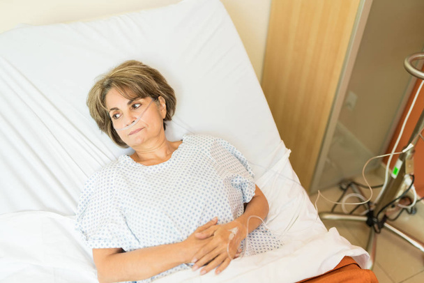 Високий кут зору вдумливого старшого пацієнта, лежачи на лікарняному ліжку
 - Фото, зображення