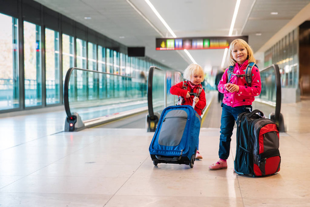 söpö pikku tytöt matkalaukut matkustaa lentokentällä - Valokuva, kuva