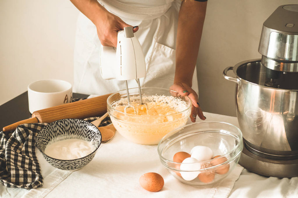 Дівчина-кондитер готує торт. Концептуальні інгредієнти для приготування борошняних виробів або десерту
 - Фото, зображення