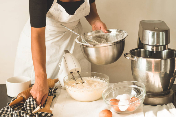 Het snoepmeisje is een taart aan het maken. Concept ingrediënten voor het koken van meelproducten of dessert - Foto, afbeelding