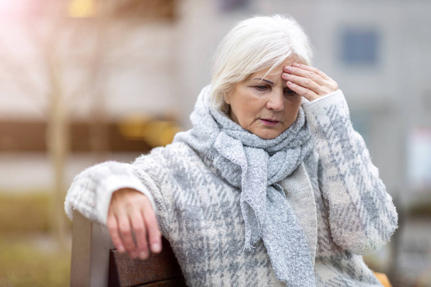 Mulher idosa que sofre de uma dor de cabeça  - Foto, Imagem