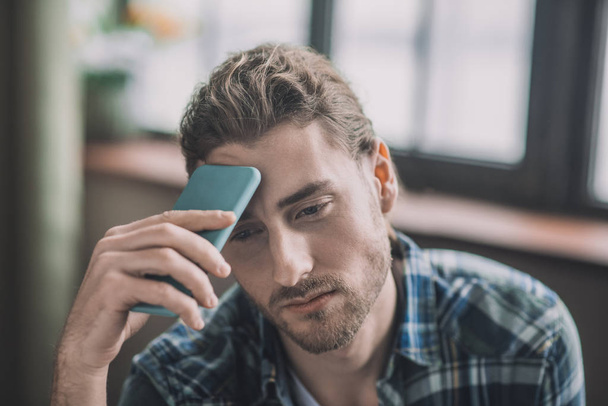Tired and frustrated men holding his mobile phone - Photo, image