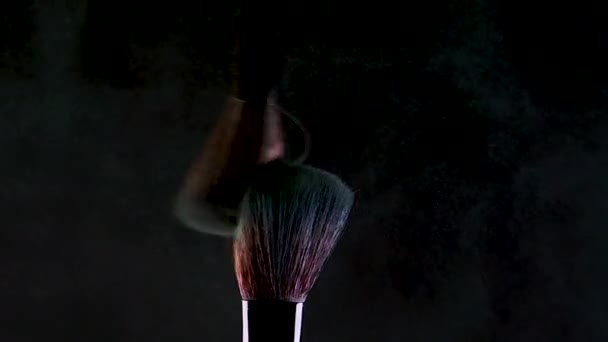 Two makeup brushes with bright eye shadow. Glitter and shadows scatter in the air - Materiał filmowy, wideo