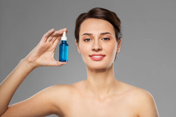 beautiful young woman with bottle of serum - 写真・画像