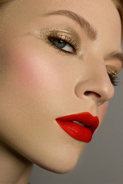 Half of a beautiful close-up of a sexy evening of a young woman make up dyed dark eyelashes and a silver liner, a beauty spa salon. Full lips with red lip gloss, clean skin and natural bare lips. - Foto, imagen