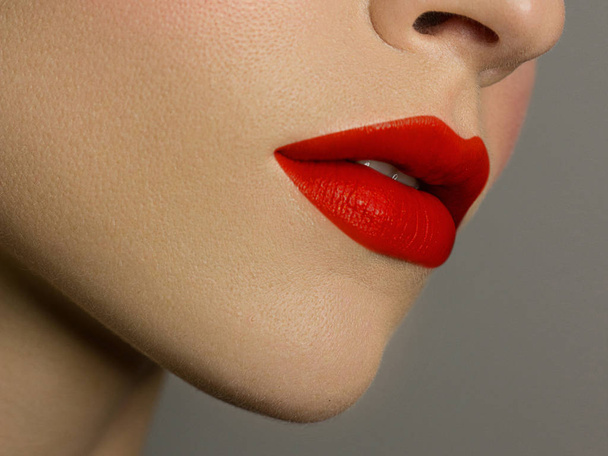 Cosmetics, makeup and trends. Bright lip gloss and lipstick on lips. Closeup of beautiful female mouth with red and pink lip makeup. Beautiful part of female face. Perfect clean skin - Φωτογραφία, εικόνα