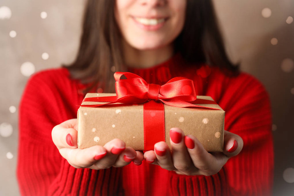 Young woman holding gift box, closeup. Space for text - Photo, image