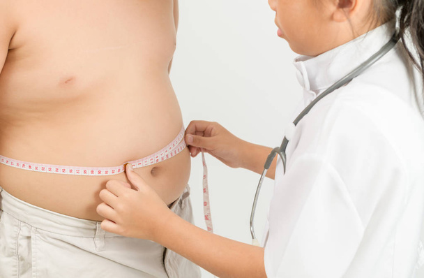 Pequeño médico que mide la grasa corporal de la cintura infantil obesa aislada
 - Foto, Imagen