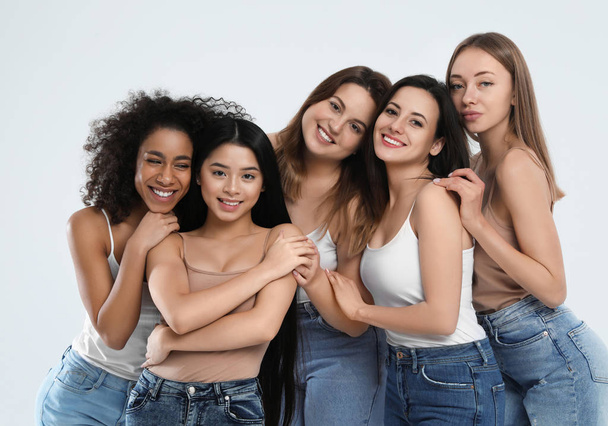 Group of women with different body types on light background - Foto, Imagen