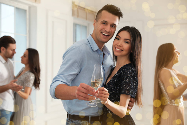 Lovely young couple with glasses of champagne at dancing party - Foto, Bild